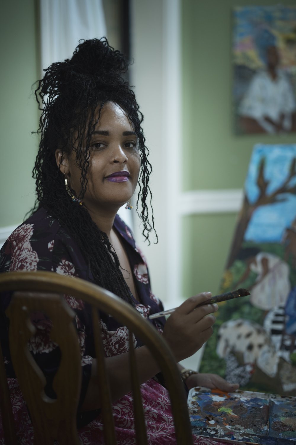 Jessica Young Broussard, painter and 2026 Creole Culture Day artist, holding a brush in her home studio
